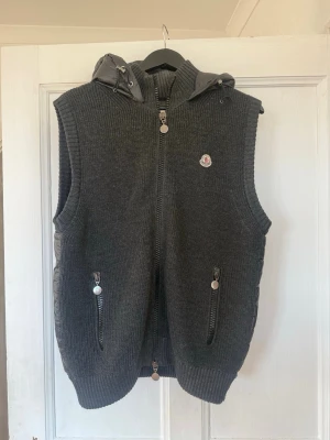 Mörkgrå dunväst från Moncler - Snygg mörkgrå dunväst från Moncler. Den är riktigt fet och perfekt för våren. Storlek L men sitter som M. Skicket är ganska bra. Priset kan diskuteras vid snabb o smidig affär:)