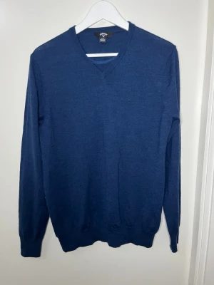 Mörkblå V-ringad tröja  - Klassisk mörkblå V-ringad tröja i mjukt material. Tröjan har långa ärmar och ribbade muddar vid ärmslut och nederkant. Perfekt för en stilren och enkel look.