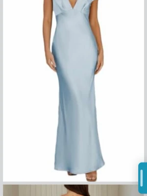 Ljusblå balklänning  - Snygg ljusblå långklänning/ balklänning med djup v-ringning och figurnära passform. Klänningen har korta ärmar och är tillverkad i ett glansigt material som ger en elegant look. Perfekt för student eller bal. Använd 1 gång, skicka till mig för fler bilder🥰🥰🥰