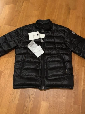 Moncler acorus jacka (med kvitto) - Säljer min svarta  acorus jacka. Storleken är 2/S och jackan är köpt på NK. Jag skulle säga att skicket är 10/10 men den är såklart lite använd därför det låga priset. Jackan sitter bra och är perfekt till våren.