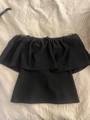 Svart offshoulder volangtop -  Snygg svart offshoulder topp från zara med bred volang runt hela axelpartiet. 