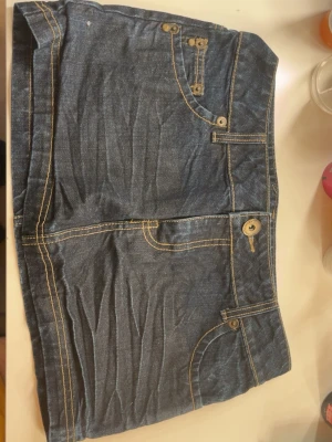 Jeanskjol med snygga bakfickor - Säljer min minikjol då den aldrig använts,superfin och perfekt längd som ger en liten vintage look. Kjolen är även lågmidjad. Finns ingen storlek i kjolen men kan skicka mått och dem passar mig som har 26 och 36 vanligtvis på jeans.