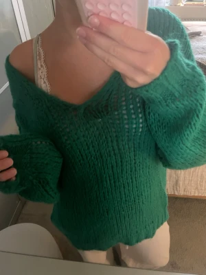 Grön stickad tröja i mohairmix - Säljer en grön stickad tröja från STANK i en luftig mohairmix (30% mohair, 30% polyamid, 40% akryl). Tröjan har v-ringning, lång ärm och oversized passform. Tillverkad i Italien och supermjuk att ha på sig.