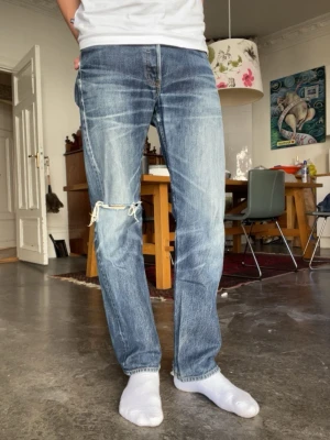 Levis 501xx - Levis jeans. Blivit lagade men har ett hål i knäet. Modellen är 180cm 65kg. Jeansen är ungefär 15år gamla. Storlek 30/36 men passar mer som 30/32 men utgå ifrån måtten. midja: 39cm längd: 101cm lår: 23cm benöppning: 20cm. Måtten kan variera 1cm+-  Fråga gärna frågor!