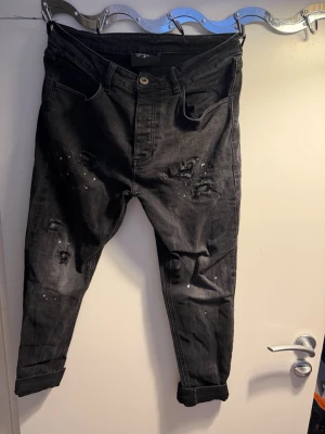 Svarta ripped jeans Kings Will Dream Paketpris Båda För 400kr  - Hej Säljer Två  par svarta Olika jeans från Kings Will Dream med slitningar och färgstänk för en edgy look. Jeansen har fem fickor, knappgylf och uppvikta benslut. Perfekta för dig som gillar streetwear och vill sticka ut lite extra. Båda som Nya!!!! Oanvända Storlek 32 på Båda Säljs Pga av Båda För små Båda För 400kr eller en För 200kr Tack! 