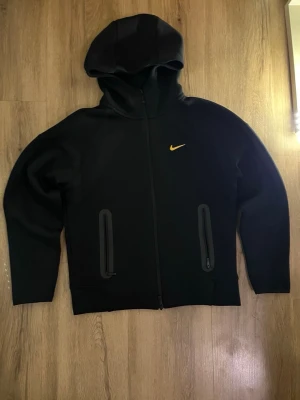 Nike NOCTA Tech Fleece set - Säljer ett svart Nike NOCTA set med hoodie och byxor. Väldigt fint skick och bekvämt material med stilren design. Passar perfekt till vardag och streetwear.