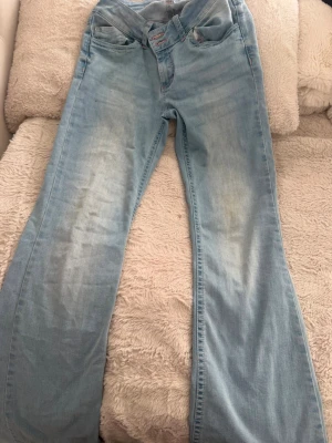 Ljusblå bootcut jeans med broderi(ordinarie pris:699kr) - Snygga low waisted ljusblå jeans med bootcut passform och klassisk femficksdesign😍. Jeansen har broderade detaljer i rosa på bakfickorna och är tillverkade i denim. Perfekta för en avslappnad och trendig look.💕