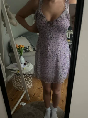 Ljuslila blommig klänning Glamorous - Söt ljuslila klänning från Glamorous med blommigt mönster i lila och vitt. Klänningen har volangkant vid axelbanden, liten rosett vid urringningen och är i ett tunt, luftigt material. Perfekt för vår och sommar! Säljer då den tyvärr är för liten för mig