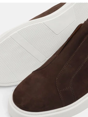 Bruna slip-on sneakers i mocka - Stilrena slip-on sneakers i mörkbrun mocka med vit, tjock sula. Skorna har en minimalistisk design utan synliga snören och kontrastsömmar längs sidorna. Perfekta för dig som gillar en clean look och vill ha något enkelt men snyggt.