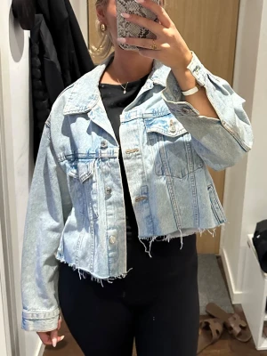 Ljusblå croppad jeansjacka - Trendig ljusblå jeansjacka med croppad passform, perfekt nu till sommaren och hösten!