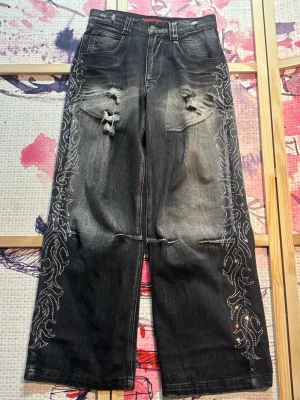 Jaded London Crystalline Colossus Jeans - Jaded London Crystalline Colossus Jeans i mycket bra skick. Använda endast några gånger, nästan i nyskick. Storlek 28 (motsvarar ungefär S). Trendiga baggy jeans med oversized/colossus fit och unik design. Perfekta för streetwear, Y2K, skater och oversized outfits. Nypris ca 1450 kr.  Jaded London Crystalline Colossus Jeans in excellent condition. Worn only a few times, almost like new. Size 28 (fits like a Small). Trendy baggy jeans with an oversized/colossus fit and unique design. Perfect for 