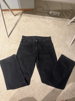 Svarta raka jeans - Säljer ett par svarta jeans med rak passform och klassisk femficksdesign från weekday. Jeansen har normal midja och är tillverkade i ett robust denimtyg. Passar perfekt till en avslappnad och stilren look. 29/32