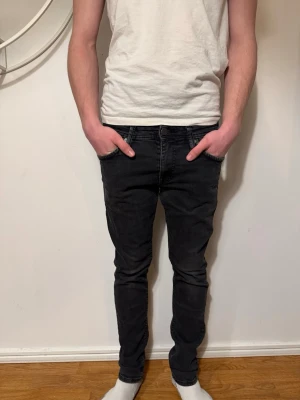 Svarta slim fit jeans från jack&jones  - Säljer ett par svarta slimfit jeans med klassisk femficksdesign och dragkedjegylf. Jeansen har smal passform och är tillverkade i stretchigt denimtyg för extra komfort. Perfekta för en avslappnad och trendig stil. W30 L32