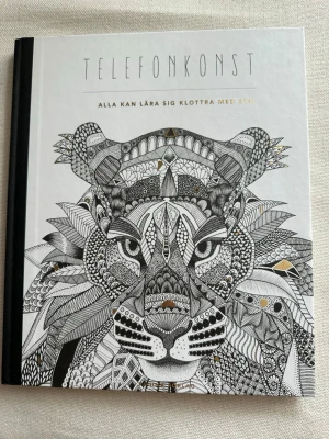 Oanvänd Telefonkonst: Alla kan lära sig klottra med stil av Angelica Lucaci - Oanvänd!  Boken "Telefonkonst: Alla kan lära sig klottra med stil" av Angelica Lucaci, även känd som Hejnum, är en kreativ bok för dig som vill lära dig att rita mönster och för dig som uppskattar kreativ avslappning. Den är för dig som bara vill ha en bok att klottra i. Att rita repetitiva mönster används som ett effektivt hjälp för personer med koncentrationssvårigheter och i terapisyfte. Oavsett vad, så är det en meditativ sysselsättning och en övning i mindfulness. ISBN: 978-91-636-1172-8.