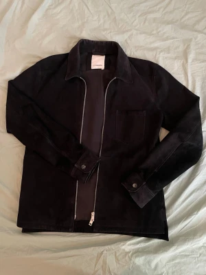 J.Linberg äkta mocka overshirt - J Linberg overshirt i 100% äkta mocka.                                  5500kr nypris men slutsåld på J Lindbergs hemsida. 2 fickor en på varje sida.                                                       Väldigt fint skick och passar perfekt nu till våren. Hör av dig vid minsta fråga och pris kan självklart diskuteras (: 