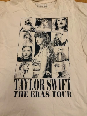 Taylor Swift The Eras Tour t-shirt - Vit t-shirt med stort svart tryck fram och bak från Taylor Swifts The Eras Tour. Framsidan har collage med bilder och text, baksidan har turnéstäder och albumtitlar. Klassisk rund hals och korta ärmar. Perfekt för fans som vill visa sin stil.