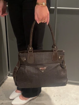 Vintage Y2K brown bag/ retro 2000s style - Unik vintage statement bag- för dig som älskar vintage, retro & 2000s stil.                                  Tidlös modell, köpt vintage.                                   Brun färg & textur mönstrad. Beiget liknande tygfoder inuti. Rymlig med flera fack/ fickor.    Väskan är använd & har små tecken på användning men inget som påverkar helhetsintrycket!!! 🩰🩰