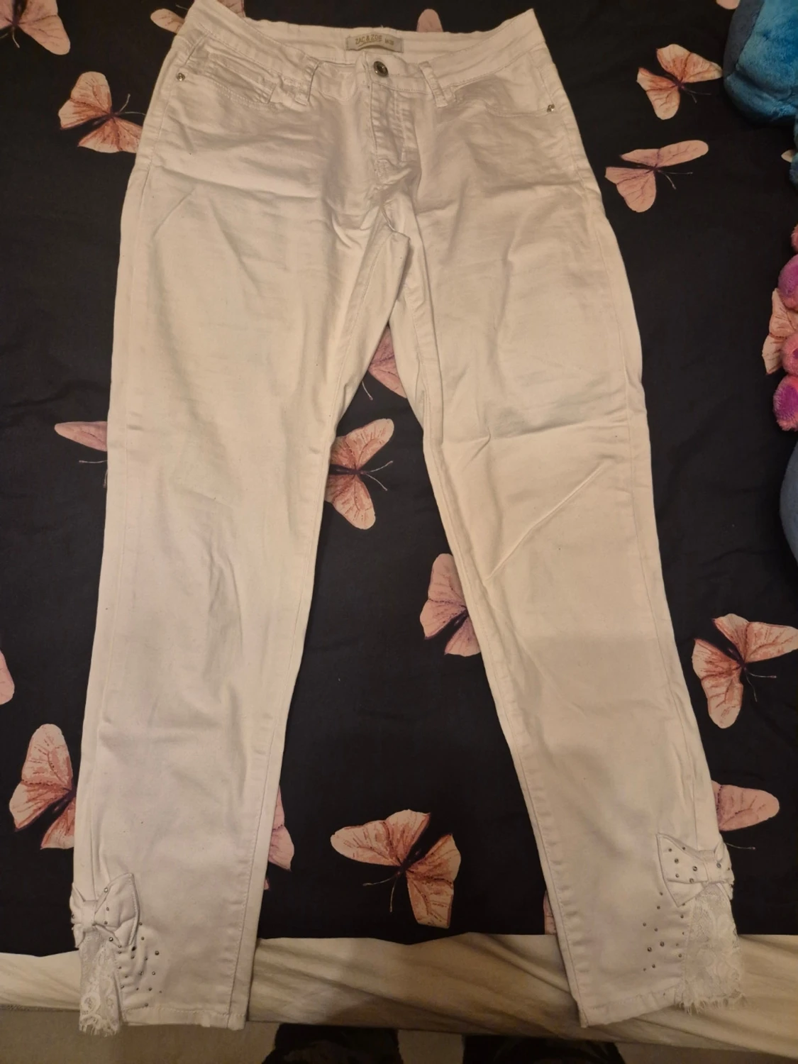 Vita jeans med spets och rosetter