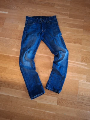 Jack and jones jeans  - Jack and jones slim Glenn i storlek 28/32 h0l på knät o ett lagat hål på låret 