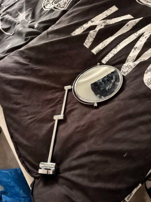 Väggmonterad rund sminkspegel silver - Snygg väggmonterad sminkspegel i rund form med silverfärgad metallram och justerbar arm. Perfekt för att fixa sminket med extra precision tack vare den flexibla armen som gör det enkelt att vinkla spegeln som du vill.