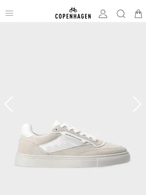 Sneakers från Copenhagen Studios - Stilrena vita/ljusgrå sneakers från Copenhagen Studios med ovandel i mocka och läder. Klassisk låg modell med perforerade detaljer på sidan och vit sula. Använda några gånger. 2 180 kr nypris. 
