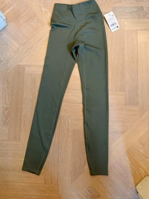 Olivgröna Tights xs - Snygga olivgröna leggings med hög midja och scrunch-detalj bak. 