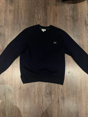Mörkblå sweatshirt från Lacoste - Inga skador eller missfärgningar, använd 2-3 gånger. Skriv gärna om ni har några frågor eller funderingar :)