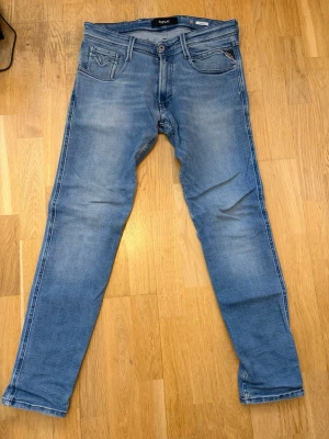 Blåa replay jeans Anbass - Ett par blåa replay jeans av modellen anbass. De är i bra skick förutom ett litet hål som du ser på bild 3. Storlek: 31 32
