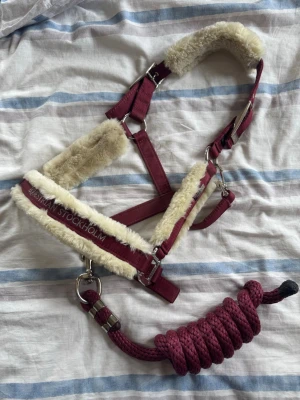 Equestrian Stockholm Grimma & Grimskaft Bordeaux/ Kantar jeździecki Stockholm i uchwyt kantara - Använt fåtal gånger på tävling  Grimma och grimskaft i röd nylon, fodrad med teddy fleece och silverfärgade beslag. Justerbar för bra passform, skonsam i vardagen  Nypris 699kr