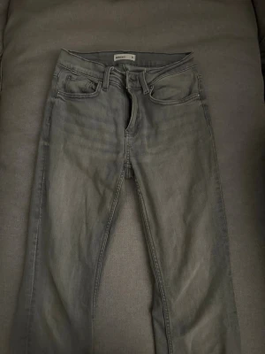 Grå low waist jeans ifrån gina tricot  - Snygga grå low waist jeans från Perfect Jeans med klassisk femficksdesign och bälteshällor. Jeansen har en stilren look och passar perfekt till en avslappnad streetstyle. Materialet är mjukt denim som ger en skön känsla hela dagen.