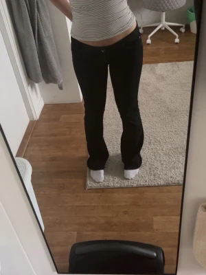 Svarta bootcut jeans - Säljer ett par svarta bootcut jeans med låg midja från weekday. Byxorna sitter som S. Innerbenslängden är 87 cm