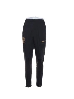 Svarta Nike träningsbyxor med guldlogga - Snygga svarta träningsbyxor från Nike med guldfärgade detaljer och klubbmärke på låret. Byxorna har smal passform, resår i midjan och dragkedjor vid bensluten. Perfekta för fotbollsträning eller gymmet.
