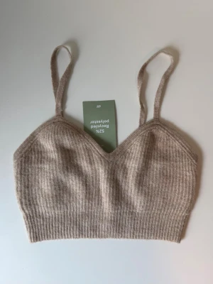 Beige ribbad topp från H&M - Trendig beige ribbad topp från H&M med smala axelband och mjuk, stretchig känsla. Passar till många olika outfits och är superbekväm 🤍