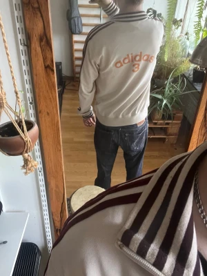 Beige Adidas ziptröja med ränder - Säljer en beige ziptröja från Adidas med vinröda ränder. Möts upp i Stockholm