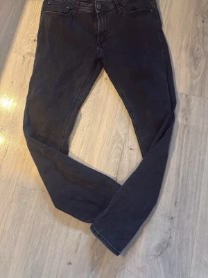 Svarta skinny jeans med låg midja - Säljer ett par svarta skinny jeans med låg midja och klassisk femficksdesign. Jeansen har smala ben och är tillverkade i stretchigt denimtyg för en bekväm passform. Perfekta för en trendig och avslappnad stil. Från Jack and Joans 32/30 