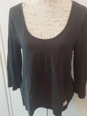 Svart långärmad topp Odd Molly - Svart långärmad topp från Odd Molly med rundad halsringning och dekorativt broderi framtill. Tillverkad i mjukt bomullsmaterial och har en liten etikett nertill. 