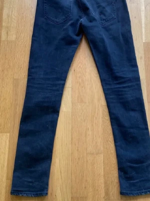 Dondup - Säljer ett par mörkblå skinny jeans med slitningar och hål på framsidan. Jeansen har klassisk femficksmodell och smal passform. Perfekta för en avslappnad och trendig look.