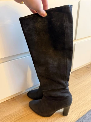 Högklackade stövlar - Säljer ett par stilrena svarta högklackade stövlar i mycket fint skick. Endast använda ett fåtal gånger, inga synliga skador eller märken. Klacken är ungefär 9 cm. Köpta från novita. Pris kan diskuteras 💗