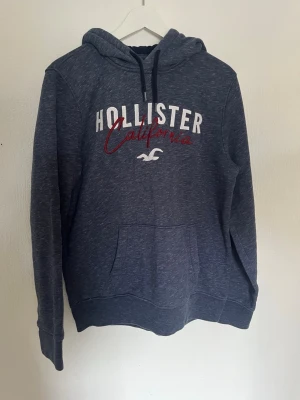 Hollister hoodie - Hej nu säljer vi denna fina hollister hoodie i en marinblå färg. Storlek på denna är M. Skick på denna hoodie är 9/10 inga defekter eller skador. För fler frågor eller funderingar är det bara att höra av skg