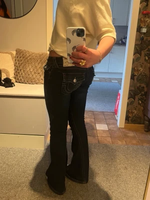 Mörkblå bootcut jeans från True Religion - Säljer ett par mörkblå bootcut jeans från True religion. Säljer dessa jeansen i joey, storlek 26 eftersom de är för stora.