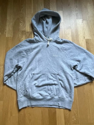 Grå hoodie från Nudie Jeans Co - Säljer en grå hoodie från Nudie Jeans Co med broderad logga på bröstet. Hoodien är köpt från careofcarl och är gjord i mjukt bomullsmaterial. Perfekt för en avslappnad och stilren look. Används ett fåtal gånger. Nypris 1399