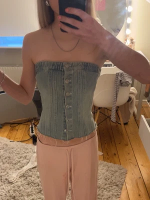 Jeans topp med knappar - Snygg tubtopp i ljusblå denim med knappar framtill. 