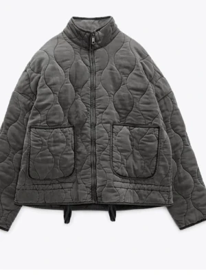 Grå quiltad jacka med fickor - Snygg grå dunjacka med quiltat mönster och två stora framfickor. Jackan har hög krage, dragkedja framtill och dragsko i nederkant för extra stilpoäng. Perfekt vår/höst jacka 🫶🏻