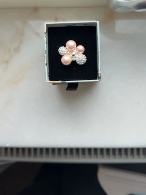 Ioaku ring - En jättefin ring från Ioaku som knappt är andvänd. Den är justerbar så passar alla. Den är i silver och med pärlor som är i champagne färg!