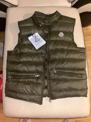 Moncler Gui  - Säljer en Moncler Gui väst. Perfekt för både vår och sommar. NFC-scan fungerar som den ska. Storlek 3, men passar även dig som har storlek 2. Dragkedjan har en mindre defekt (går att fixa), men fungerar fortfarande utan problem. Pris kan diskuteras 🤝🏻💯
