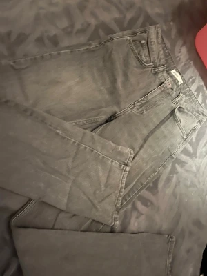 Gråa straight fit jeans Perfect Jeans - Säljer ett par gråa straight fit jeans från Gina Tricot . Klassisk femficksmodell med knappgylf och bälteshällor. Jeansen har en snygg tvättad look och är tillverkade i ett mjukt denimtyg som passar till många olika stilar.