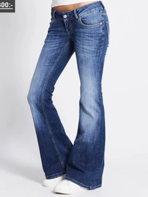 Jeans lager 157 xxs short lenght  - Snygga blå bootcut jeans med utsvängda ben och klassisk femficksdesign. Jeansen har en normal passform upptill och är tillverkade i ett mjukt denimtyg. Perfekta för dig som gillar en retroinspirerad look.