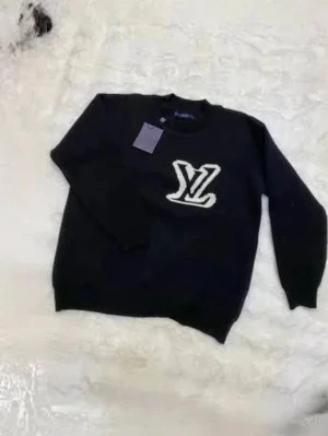 Svart tröja med LV-logga - Snygg svart tröja från Louis Vuitton med stor vit LV-logga på bröstet. Tröjan har rund halsringning och långa ärmar. Perfekt för dig som gillar exklusiva streetwear-plagg och vill sticka ut med en ikonisk logga.