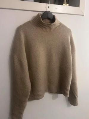 Beige stickad polotröja - Säljer en beige stickad polotröja med avslappnad passform och ribbade muddar vid ärmslut, nederkant och hals. Den är från Zara i storlek M. Ny pris 399💗