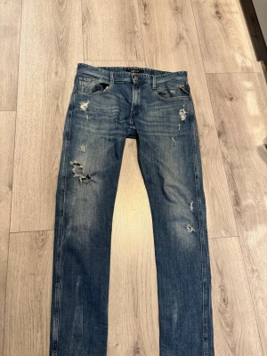 Blå slitna jeans från Replay - Säljer ett par blå jeans från Replay med snygga slitningar och distressed. Säljs för endast 550